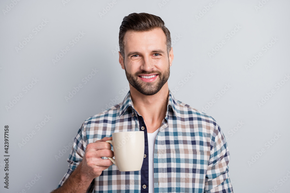 Portrait of attractive cheerful guy wear checked shirt drinking beverage caffeine isolated over gray pastel color background Portrait of attractive cheerful guy wear checked shirt drinking beverage caffeine isolated over gray pastel color background