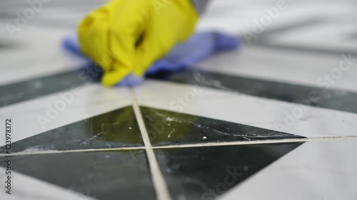 ceramic tiles, black and white, marble pattern, with stains, modern renovation, floor drawing, close-up, hands in yellow gloves washing grouting, prepare for moving, clean after repairs, clean company