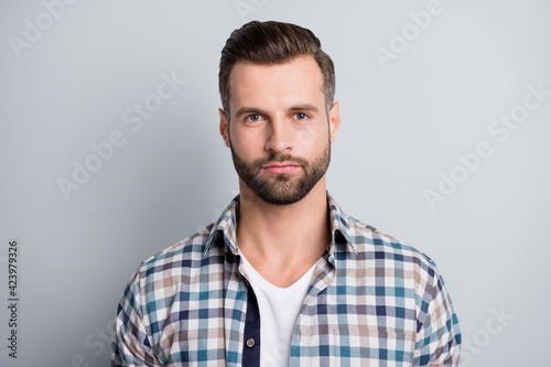 Photo of young attractive handsome serious good looking businessman in checkered shirt isolated on grey color background