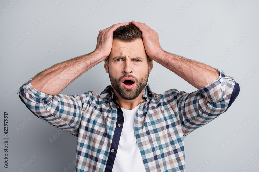 Photo of young unhappy upset stressed depressed amazed man hear shocking news isolated on grey color background Photo of young unhappy upset stressed depressed amazed man hear shocking news isolated on grey color background