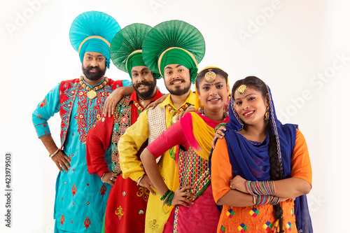 A Troupe of Punjabi Folk dancers standing together forming a vertical diagonal queue.	 photo