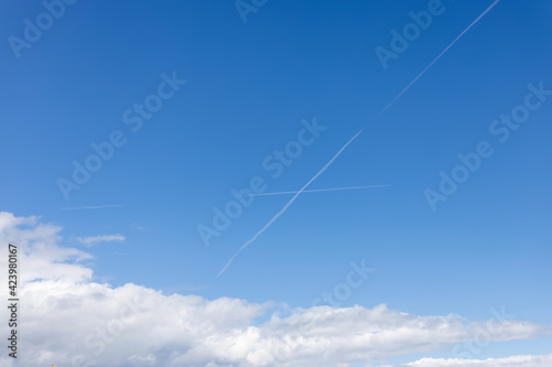 Blue sky with interesting crossing vapour trails - chemtrail