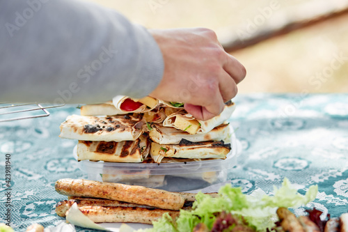 Man is serving bbq sausages with letuk lettuce leaves. Spring summer season  photo