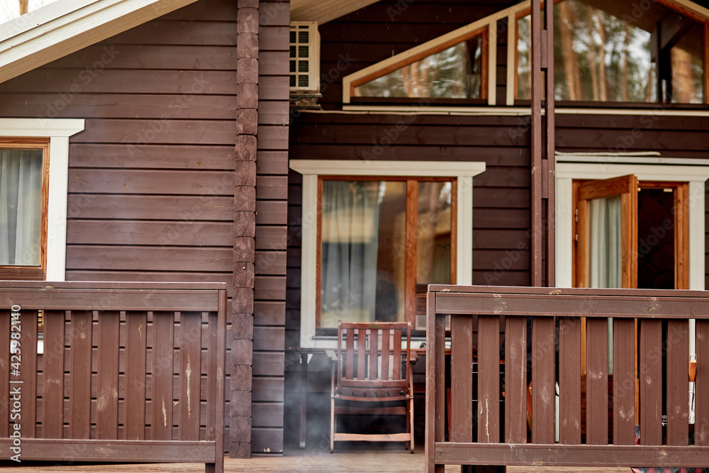 Cozy wooden house with smoke from bbq. Spring season concept Cozy wooden house with smoke from bbq. Spring season concept