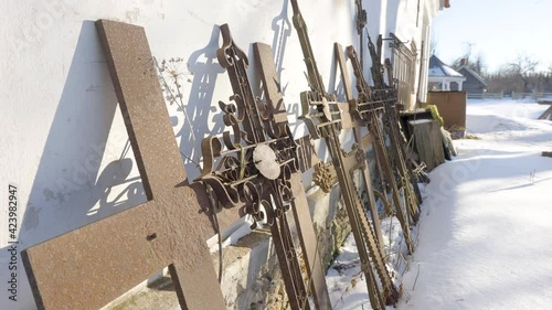 The side view of the metal rusty cross on the ground with the thick snow on the ground photo