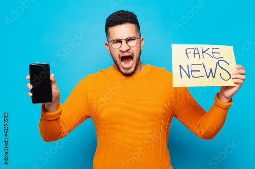 young hispanic man angry expression fake news concept photo