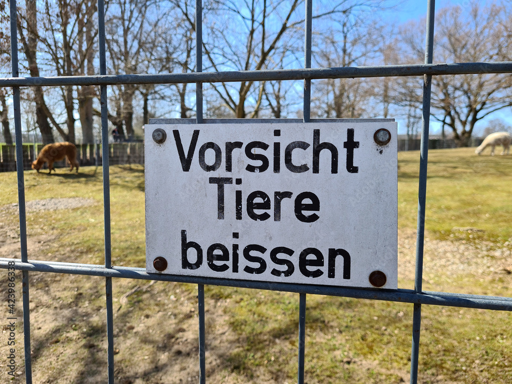 schild an einem zaun in einem zoo vorsicht tiere beissen schild an einem zaun in einem zoo vorsicht tiere beissen