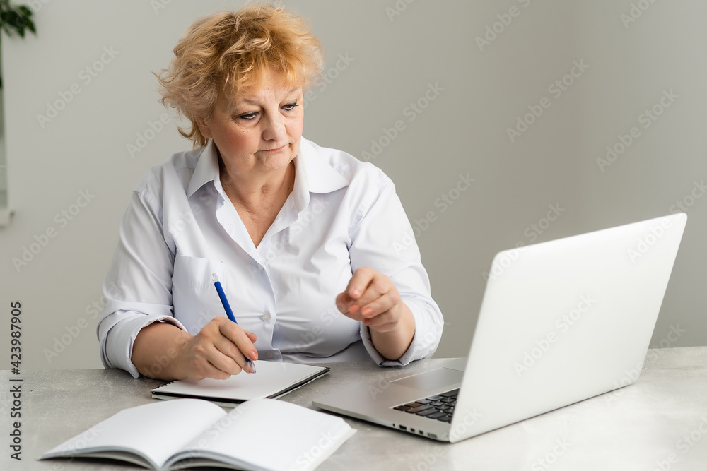 Side view of a female pensioner using laptop at home Side view of a female pensioner using laptop at home