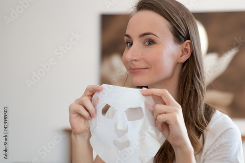 Young woman doing purifying mask on her face