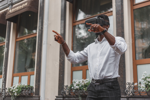 African businessman use virtual reality glasses on the street. VR headset