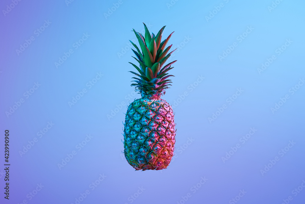Pineapple fruit in blue and pink neon lights
