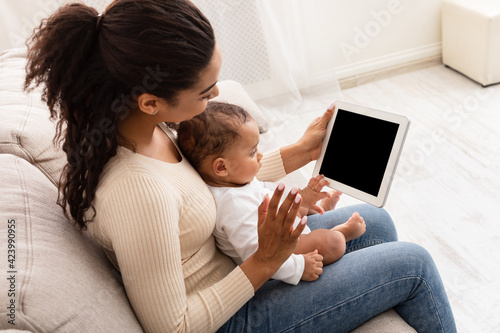 Black Mother With Toddler Baby Video Calling Using Tablet Indoor