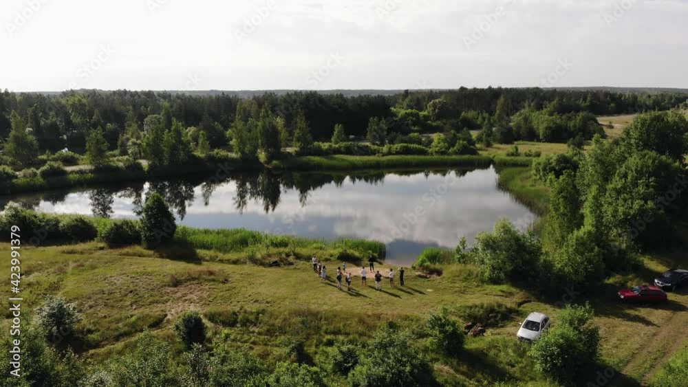 Shooting with quadcopter a group of people from a standing on the shore of a lake and the reflection of the clouds in one of the lakes Shooting with quadcopter a group of people from a standing on the shore of a lake and the reflection of the clouds in one of the lakes