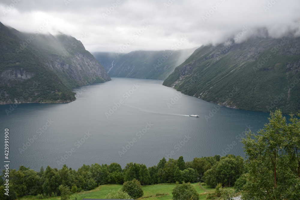 Obraz premium River bay with boat, mountains, clouds and forests