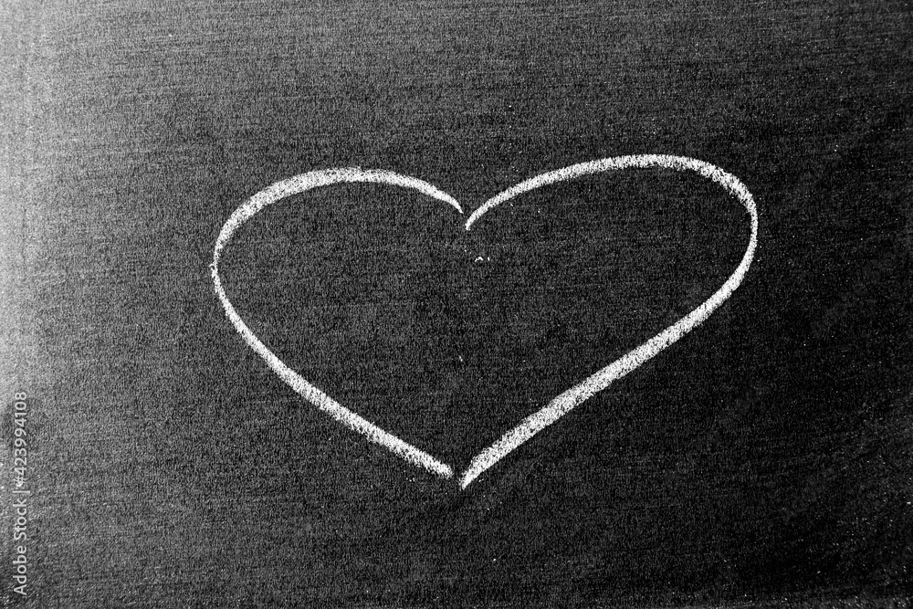 White color chalk hand drawing in heart shape on blackboard or chalkboard background White color chalk hand drawing in heart shape on blackboard or chalkboard background