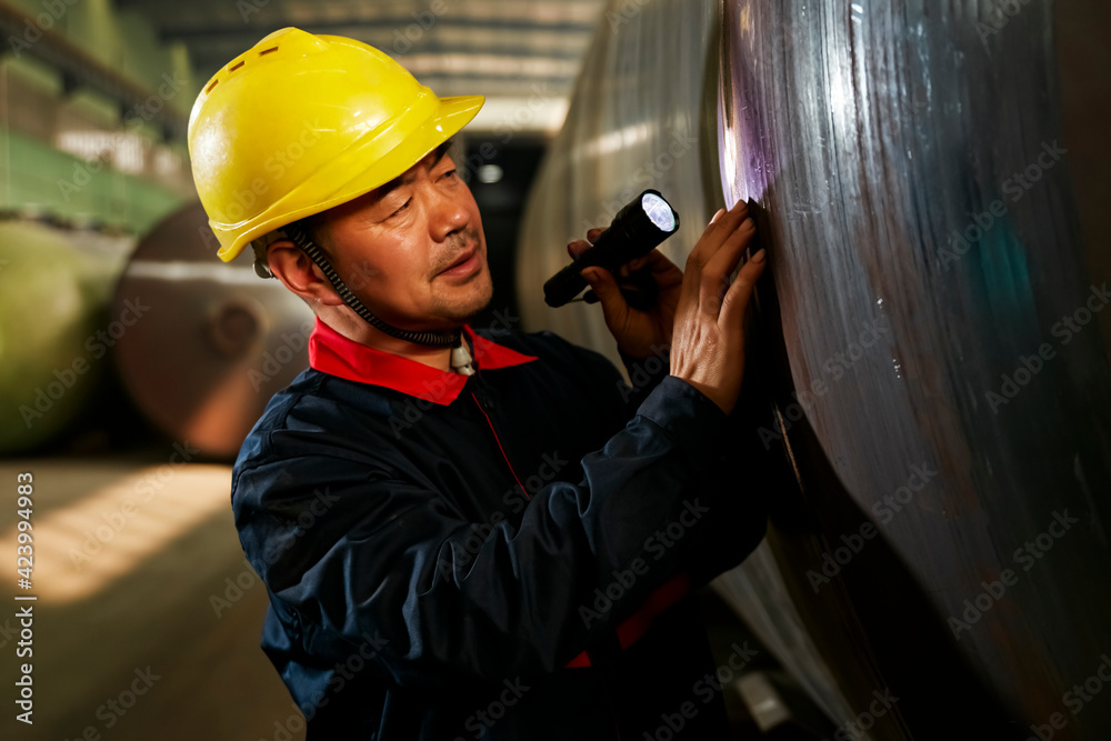 Flashlight Using Contuction Worker Asian workers are using flashlights to look at the details of the steel ...