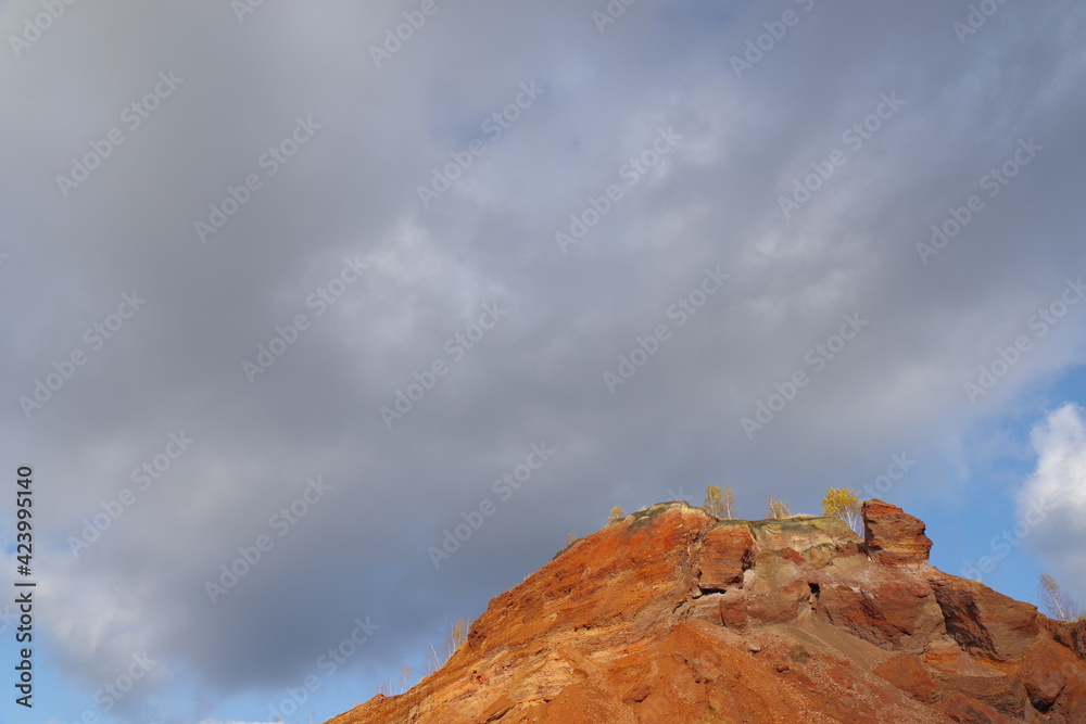 Red hills with birches against a blue sky. Red hills with birches against a blue sky.