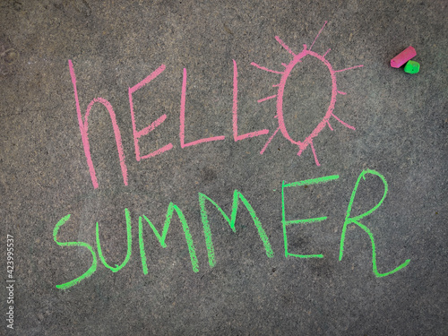 The inscription text on the grey board, Hello Summer. Using color chalk pieces.