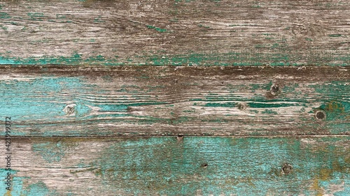Old brown-blue wooden background with peeling paint and green mildew. Natural wood in grunge style. Top view. Raw planed texture of coniferous pine. Surface of table to shoot flat lay. Copy space.