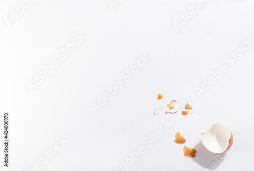 Scattered gold eggs, shell on pastel beige background.