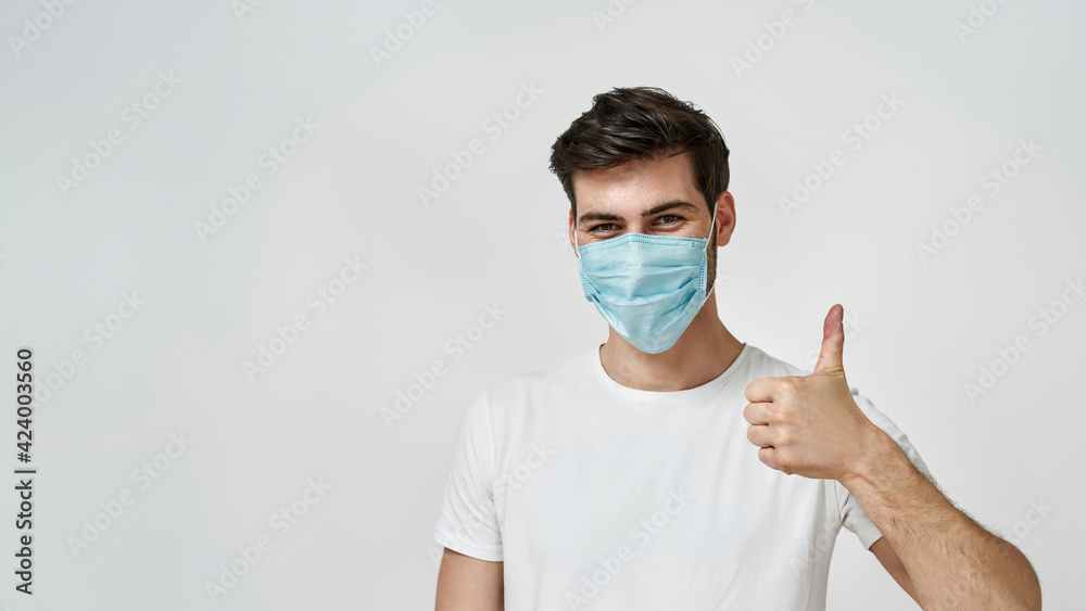 Man wearing medical mask showing the thumbs up Man wearing medical mask showing the thumbs up