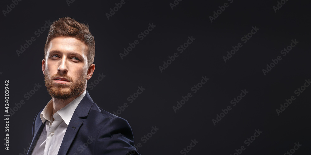 A man wearing a suit and tie on black background A man wearing a suit and tie on black background