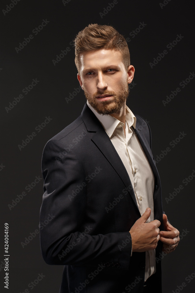 A man wearing a suit and tie on black background A man wearing a suit and tie on black background