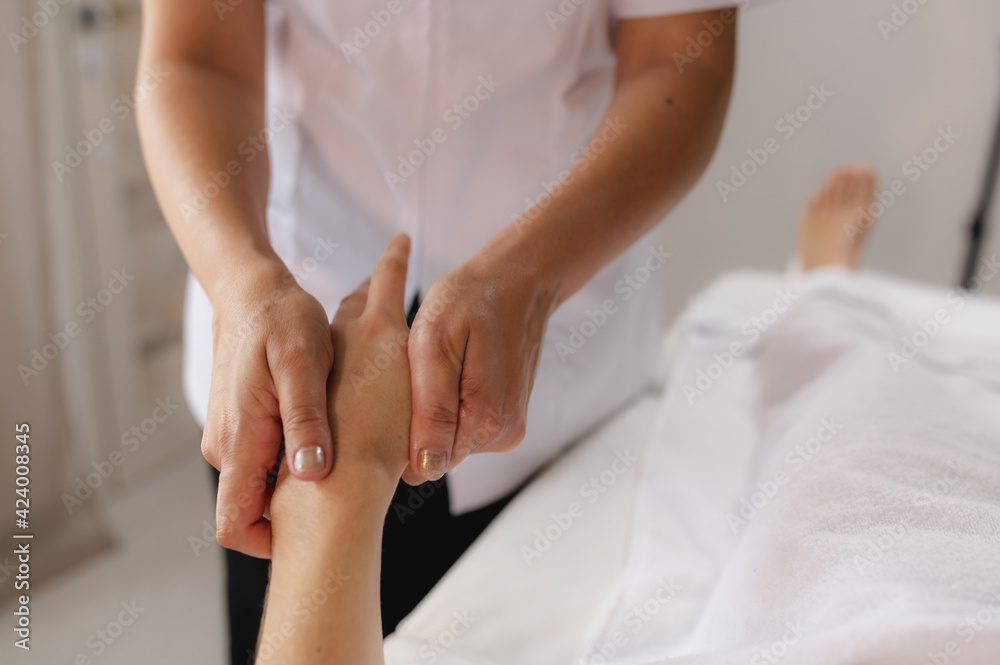 Unrecognizable women in a spa. Therapist making relaxing hand massages. Unrecognizable women in a spa. Therapist making relaxing hand massages.