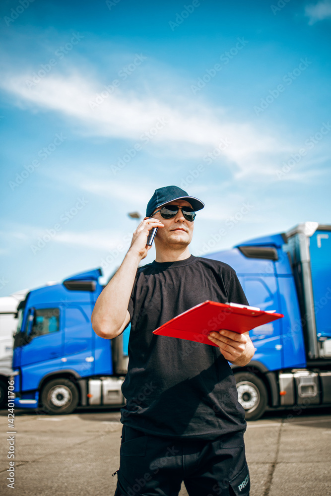 Professional truck driver with hat and sunglasses confidently standing