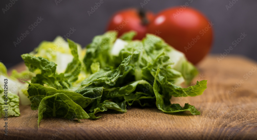 Fresh salad and tomatoes on a wooden board - studio photography Fresh salad and tomatoes on a wooden board - studio photography