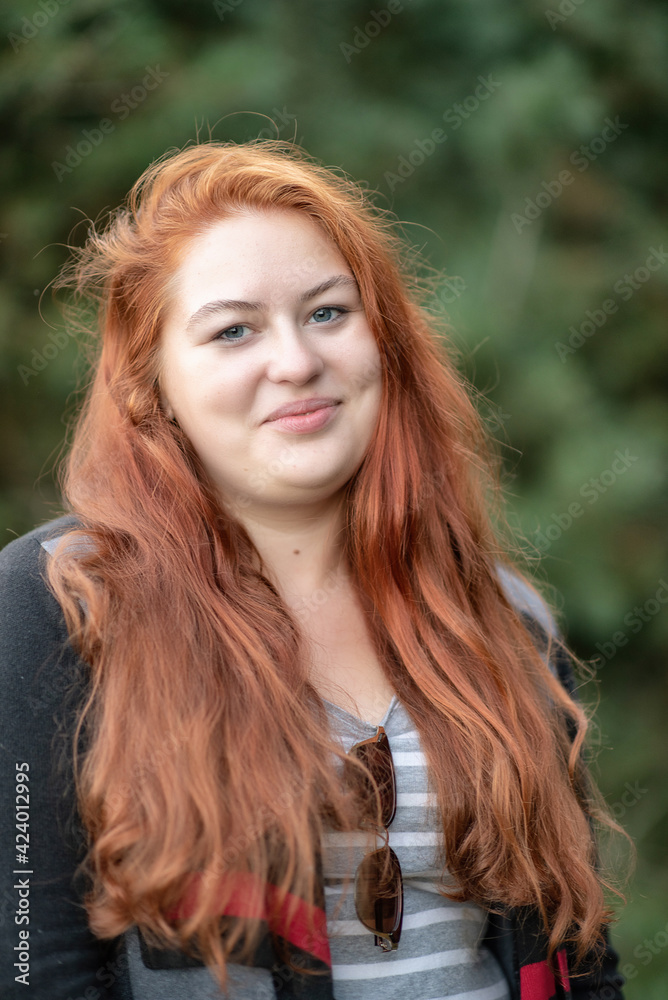 Portrait of a young beautiful red-haired plump girl in the forest. Portrait of a young beautiful red-haired plump girl in the forest.
