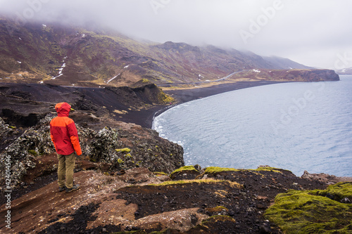 Tourist looking at black beach of Lake Kleifarvatn near Krysuvik in Iceland, top view