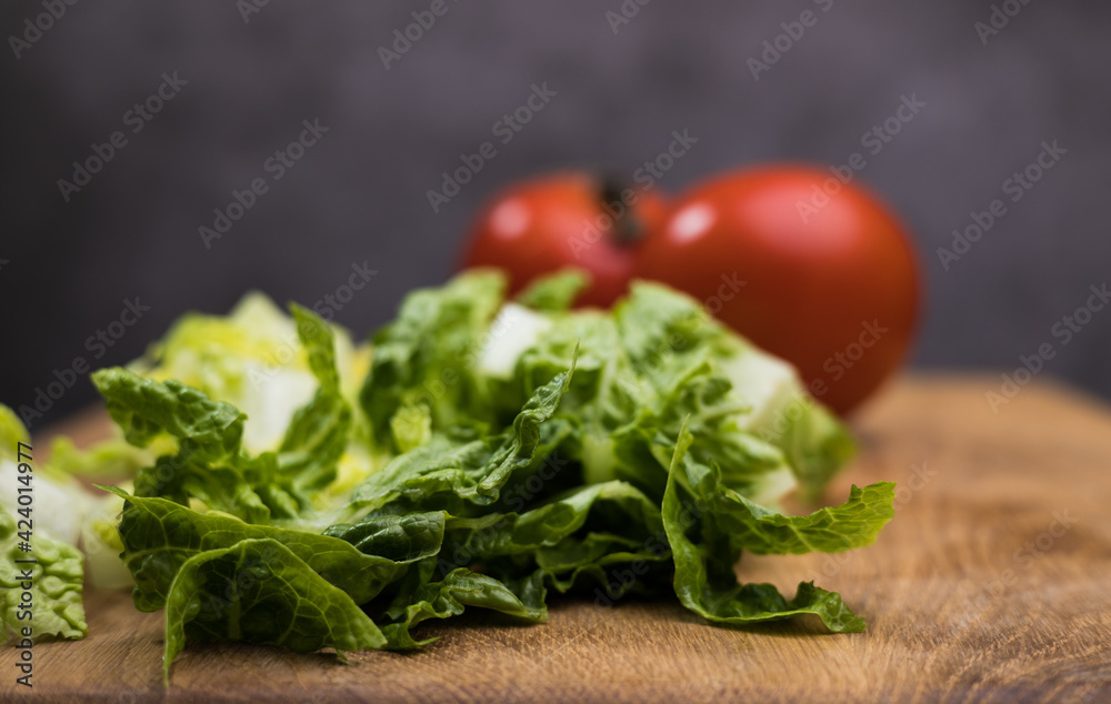 Fresh salad and tomatoes on a wooden board - studio photography Fresh salad and tomatoes on a wooden board - studio photography