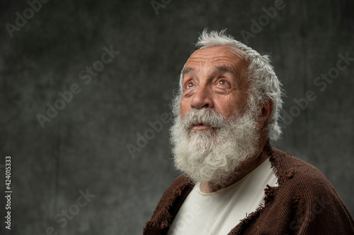 Portrait of old man wirth beard looking up