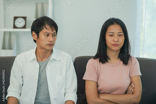 Man sitting back to back to his wife after quarrel at home