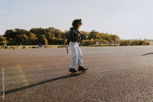 Young woman skating in park on sunny day