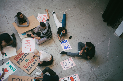 High angle view of female and male protestor preparing signboards for human rights