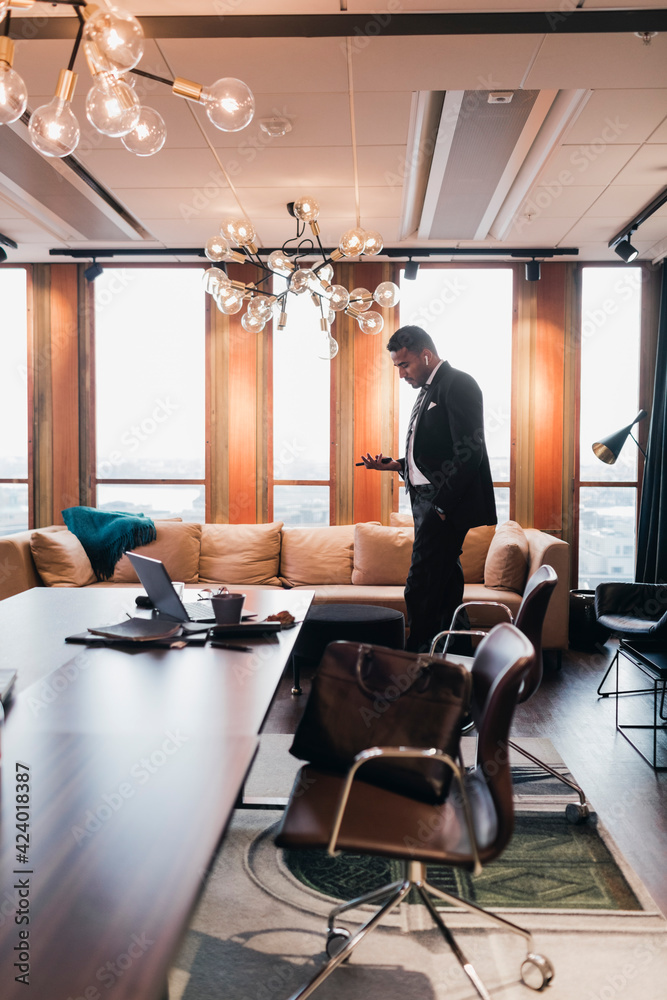 Side view of male entrepreneur walking in board room at office Side view of male entrepreneur walking in board room at office
