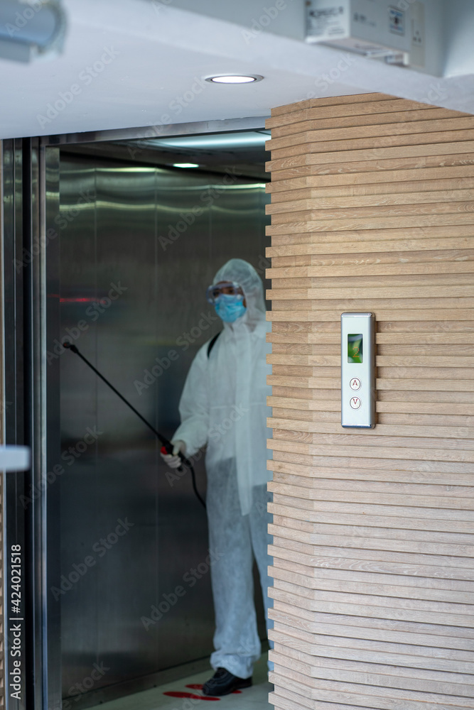 Asian healthcare medical workers wearing PPE protective suit disinfecting to building in new normal 