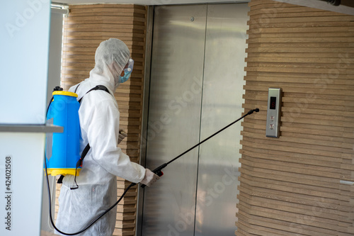 Asian healthcare medical workers wearing PPE protective suit disinfecting to building in new normal 