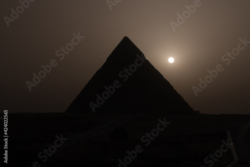 View of the pyramid of Khafre  one of the three ancient Egyptian pyramids of Giza  during a sandstorm with the setting sun conveying a mystical experience