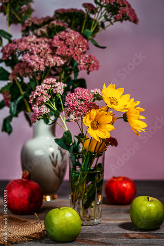 Wallpaper Mural Bouquet of flowers in a vase next to apples and pomegranate on a wooden table Torontodigital.ca