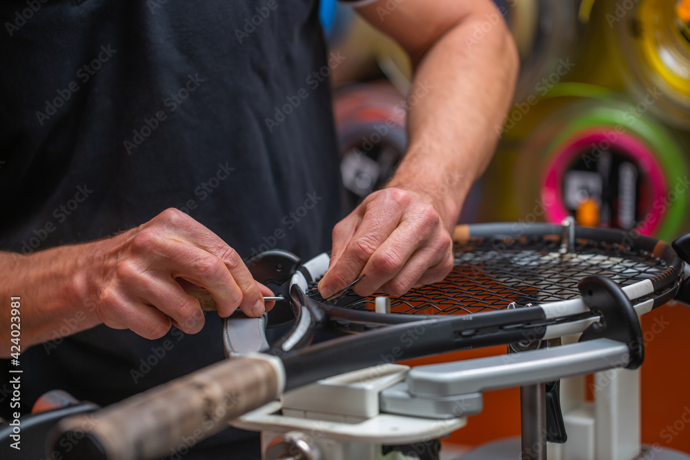 Process of stringing a tennis racket in a tennis shop, sport and leisure concept Process of stringing a tennis racket in a tennis shop, sport and leisure concept