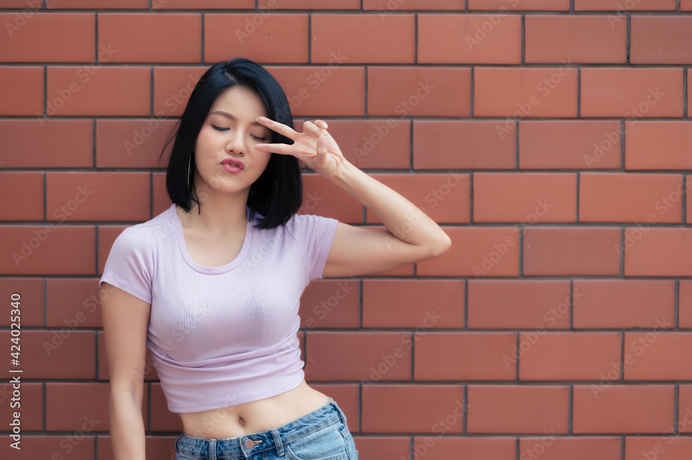 Portrait of hipster girl  on brick wall background,Beautiful asian woman pose for take a photo