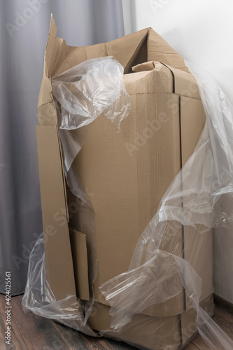 torn large box indoors against the wall