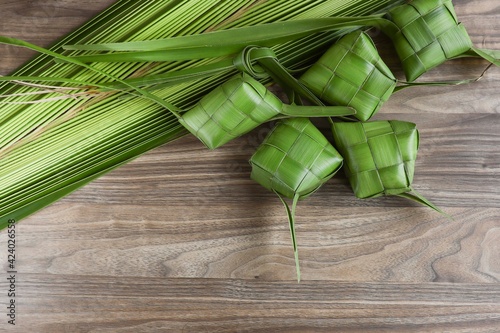 Ketupat or rice dumpling on the wooden table.  Made from young cocnut leaves