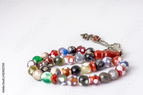 Close up colorful men's Muslim Prayer beads on white background, Ramadan concept 