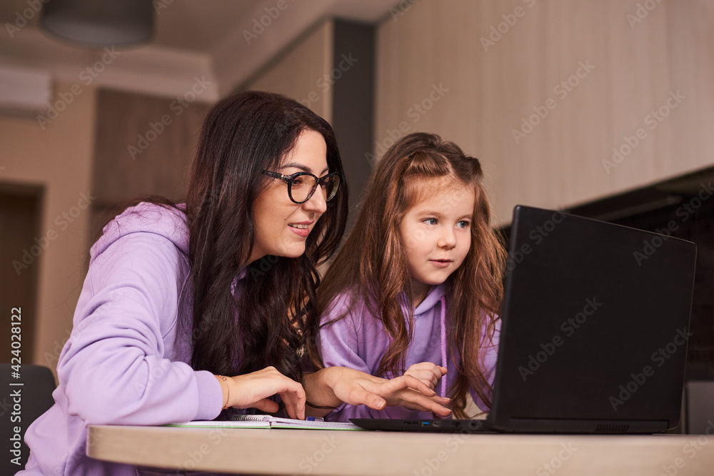 woman and girl doing homework online. Distance learning online education. Mother and daughter happy together at home