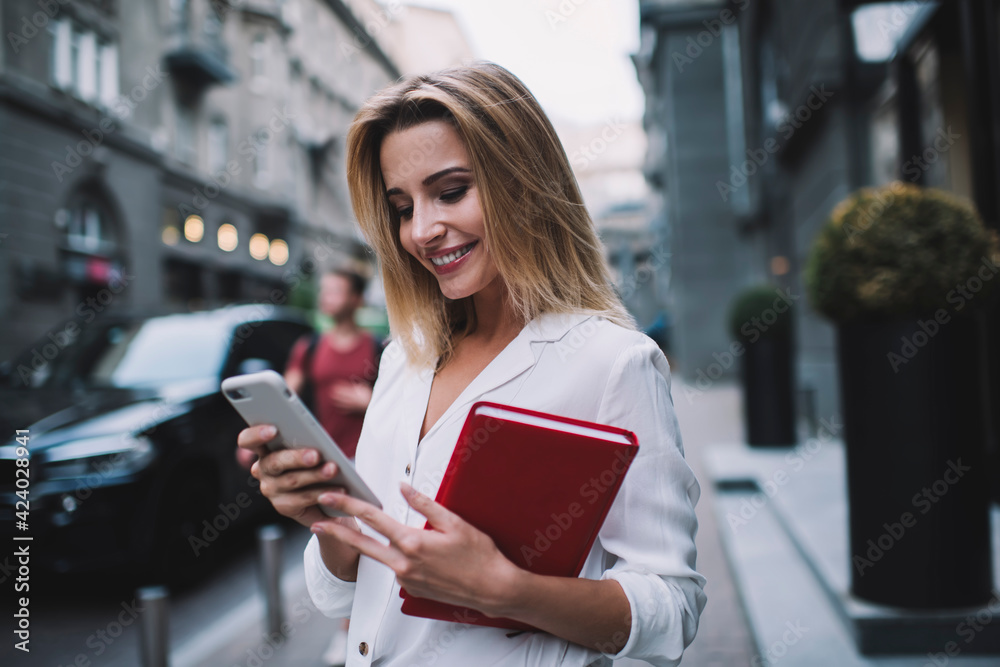 Positive formal woman using smartphone on street