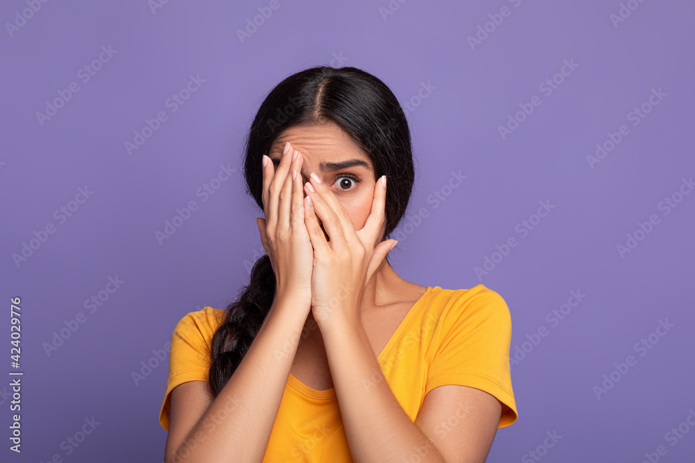 Omg. Portrait of shocked young indian woman covering one eye Omg. Portrait of shocked young indian woman covering one eye
